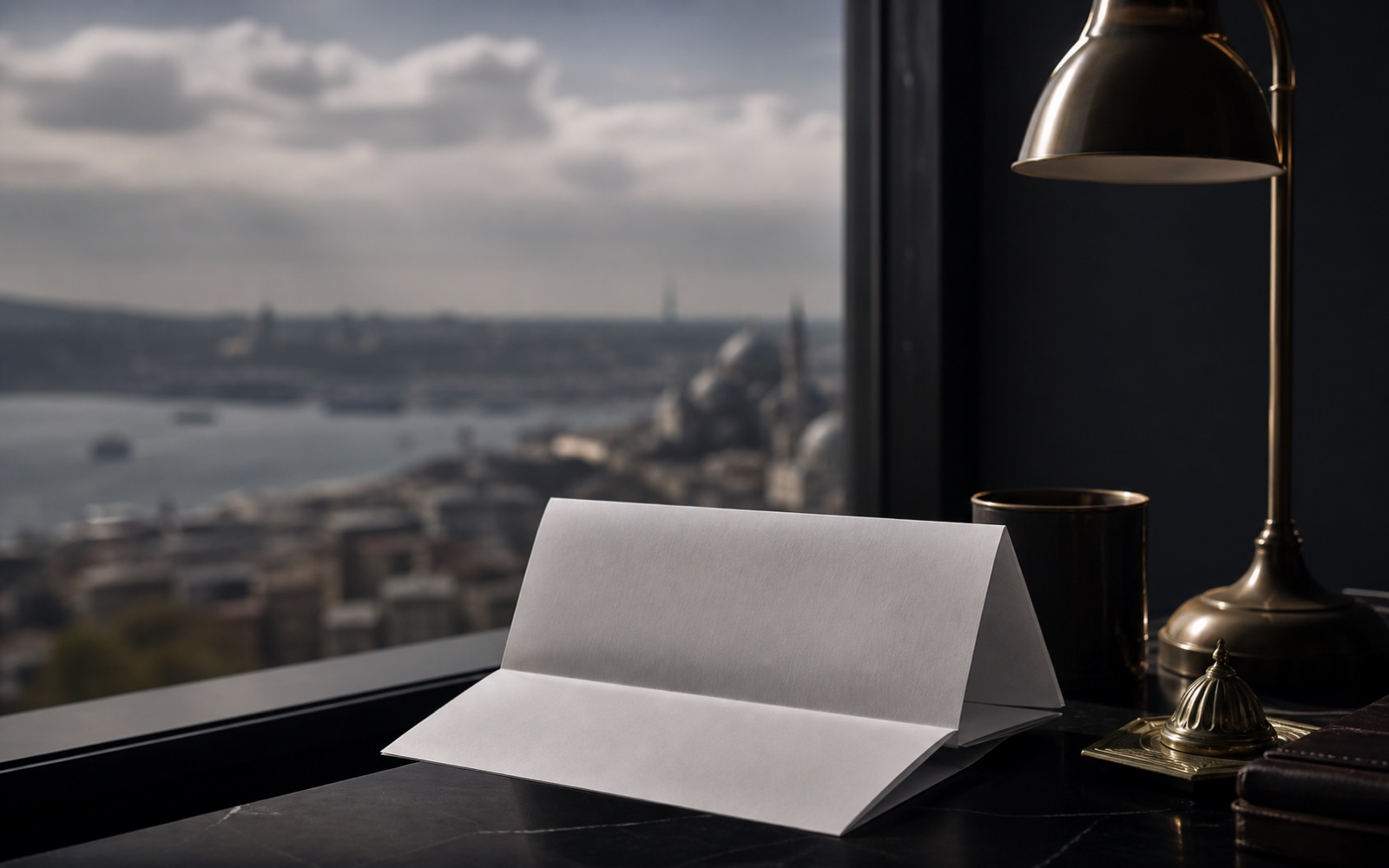 A monthly bank statement folded on a windowsill, city light behind it